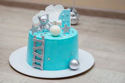 Niebieski tort na 1 urodziny na srebrnej cienkiej podkładce